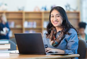 Smiling educator sitting infront of a laptop