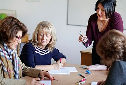 Educators around a table being instructed by a facilitator