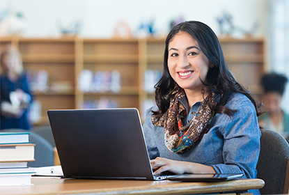 Smiling educator sitting infront of a laptop