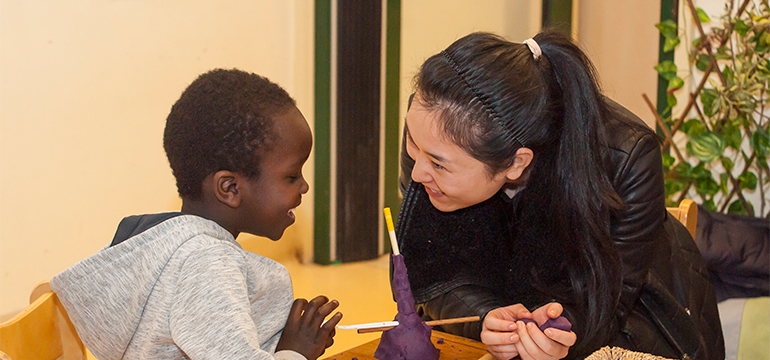 Educator and child looking at each other