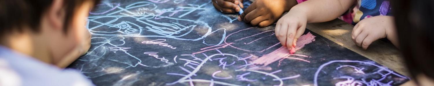 Group of kindergarten children drawing outdoors