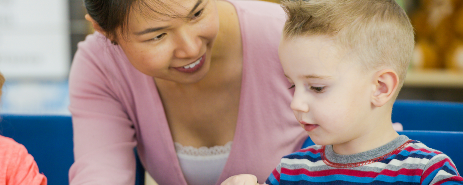 educator and child sitting at table