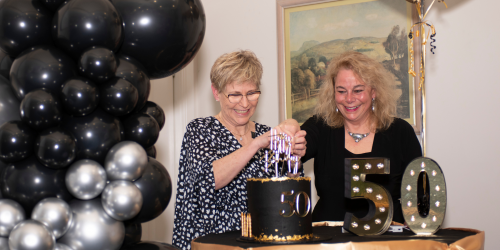 Julie Price and Linda Davison cut 50th birthday cake.