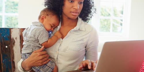 Mother holding child using laptop