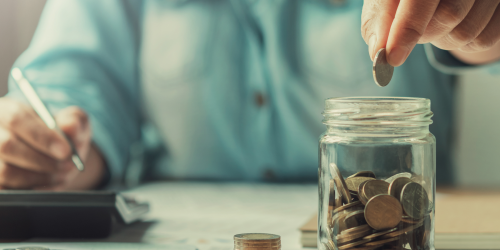 Woman is counting coins into a jar