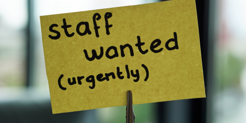 Photo of a post it note that reads "staff wanted (urgently)"