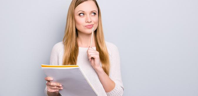 Woman holding paperwork with a thoughtful expression