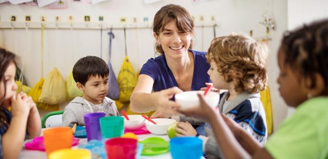 Teacher and children at meal time