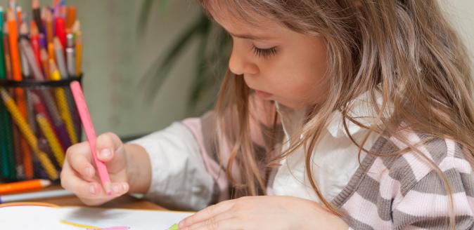 A child drawing with coloured pencils