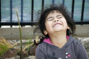 Joyful child with head titled to the sky with eyes closed