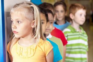 Young, school-aged children lining up behind one another