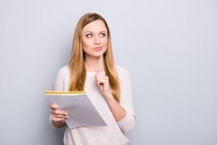 Woman holding paperwork with a thoughtful expression