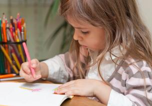 A child drawing with coloured pencils